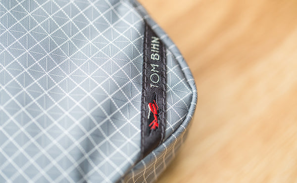 A close-up shot of the corner TOM BIHN label on the 3D Organizer Cube.